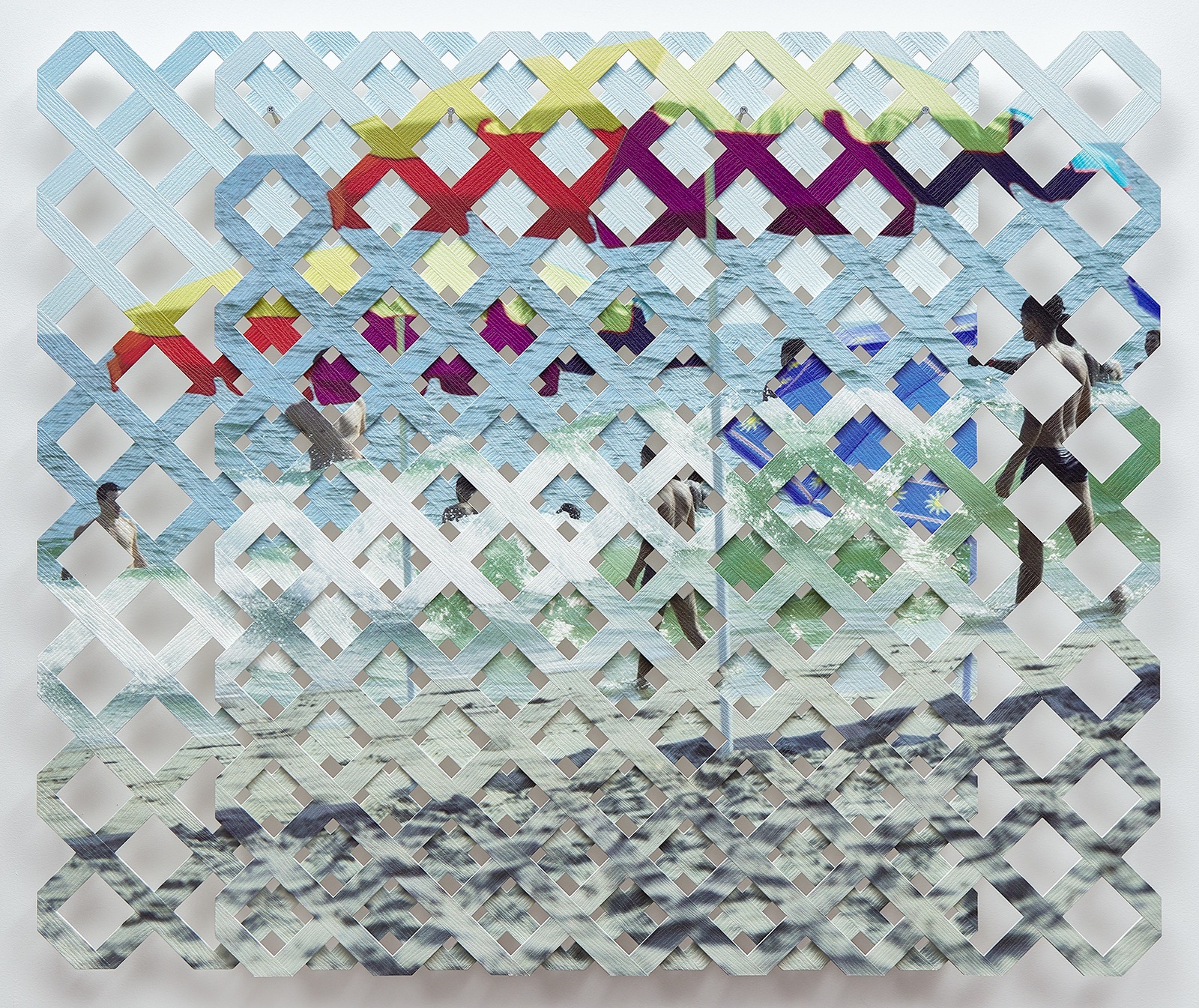 An image of a beach scene printed on two sheets of lattice, one panel more zoomed-in than the other, hung overlapping so the image appears duplicated and off-set. 
